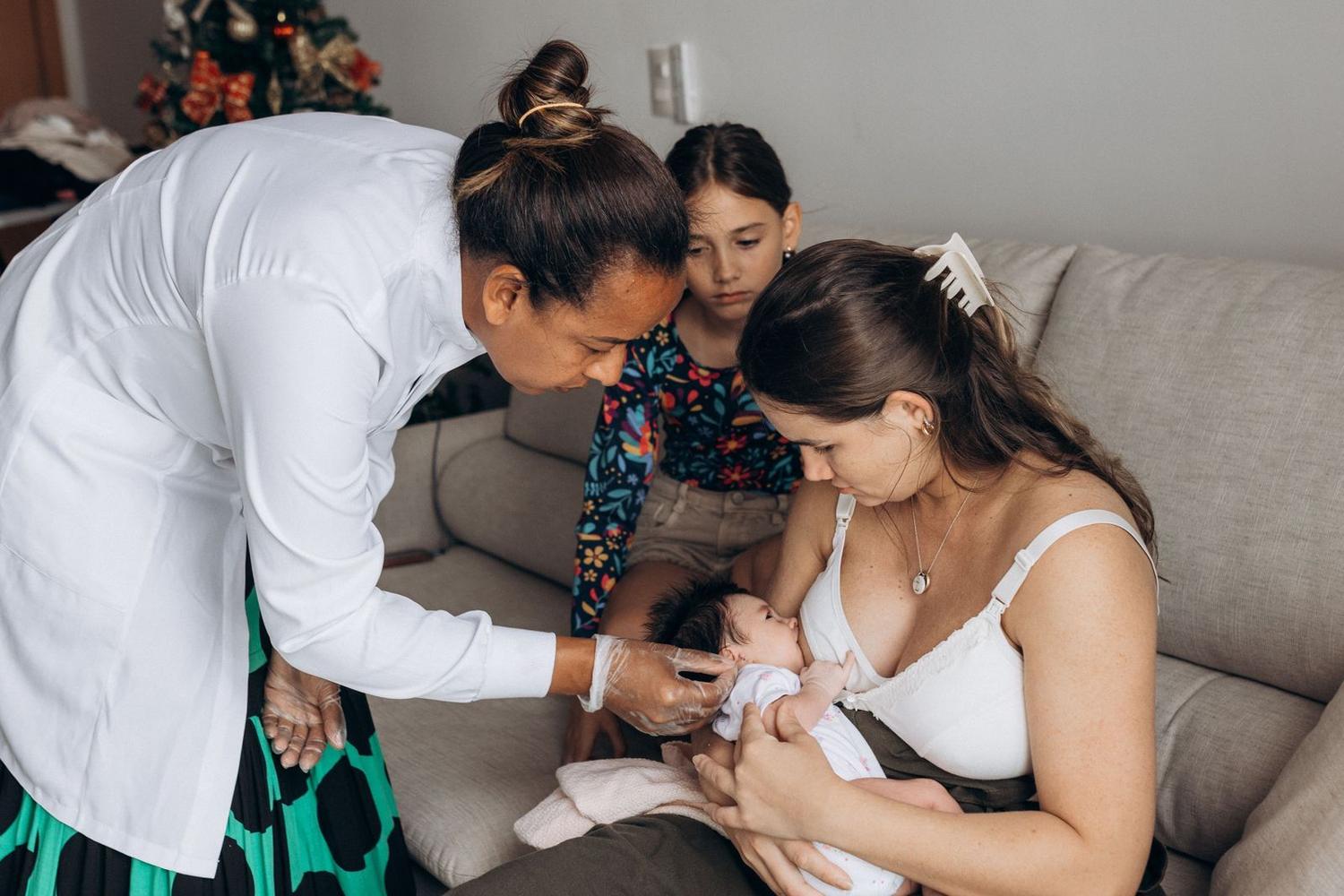 A health worker supporting a mother and newborn at home