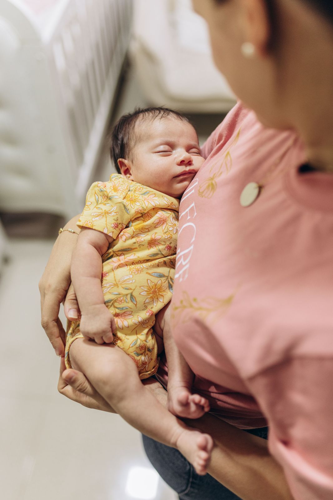 A parent holding their sleeping newborn
