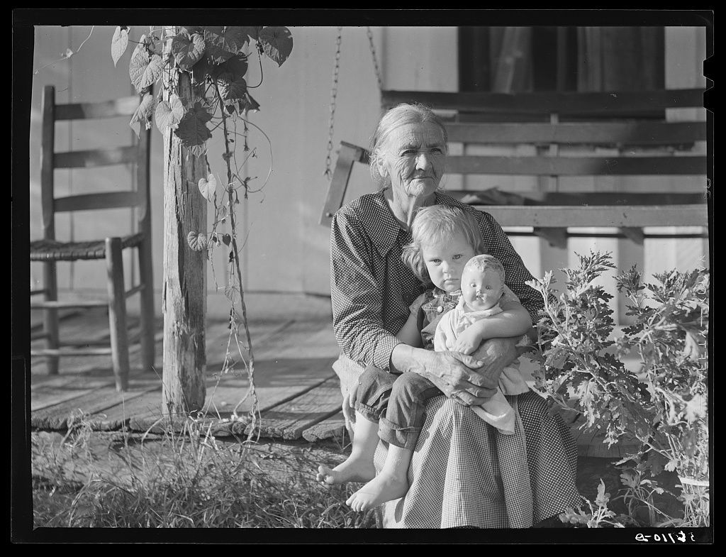 A historic photograph of an older woman and a young child on a porch